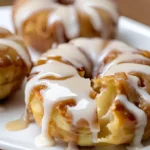 Stack of freshly baked apple fritters drizzled with sweet glaze.