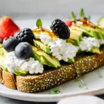 Avocado toast with cottage cheese, berries, and honey.